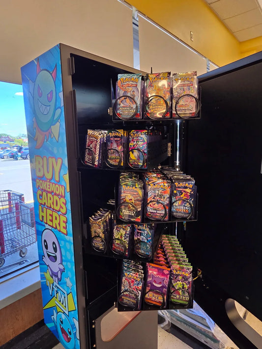 Open VTM trading card vending machine with Pokemon booster packs racked in top-loader cases