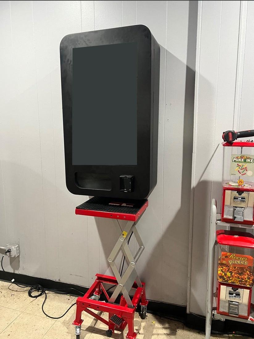 VapeTM hydraulic lift raising a vending machine to mounting height to reduce labor and injury